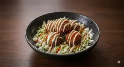 Falafels over shredded cabbage with sauce